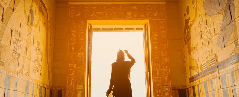 A traveller walking through a sunlit temple doorway